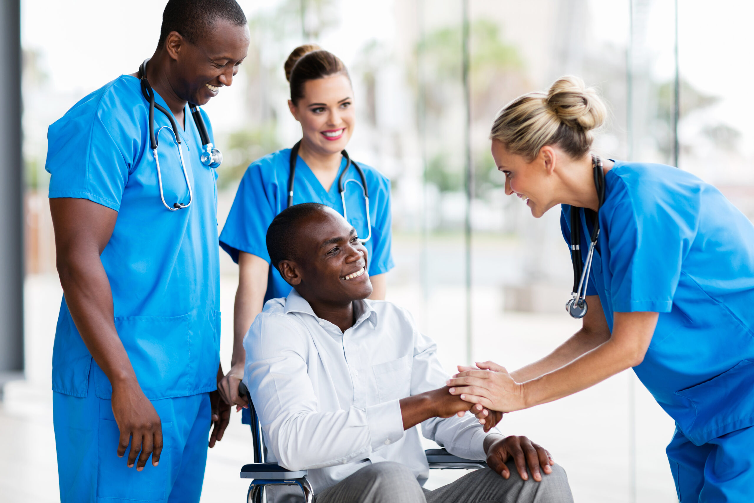 female doctor greeting patient in a wheelchair