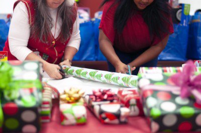 two women cutting wrapping paper
