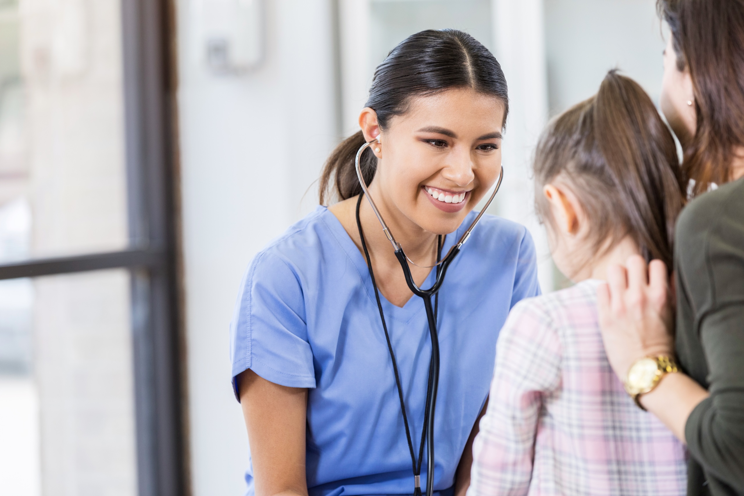 Hero image: Cheerful pediatrician listens to young patient