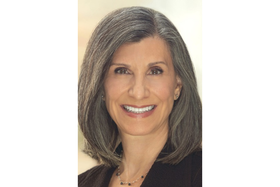 A smiling woman with shoulder-length gray hair.